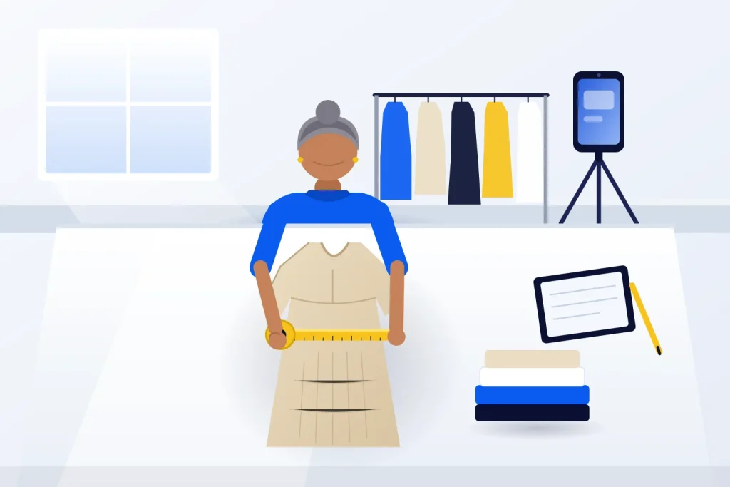 Dona de loja de moda mede vestido de linho sobre a mesa do estoque, com araras e celular em tripé para fotos de produto ao fundo